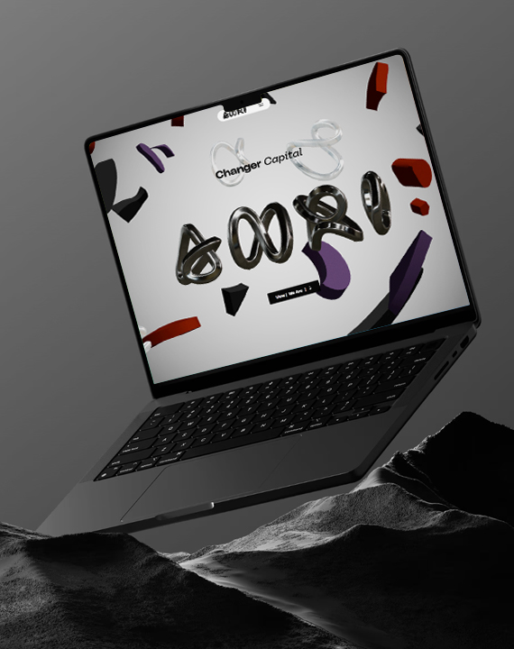 Laptop displaying "Changer Capital" website on rocks